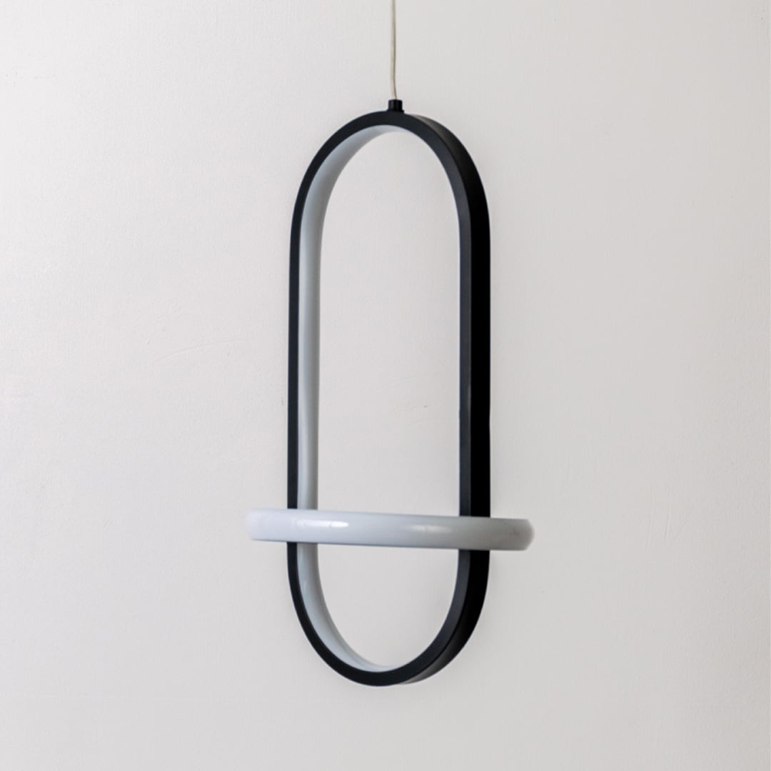 Modern black and white metal oval hanging light shown switched off on white background for minimal home decor styling.