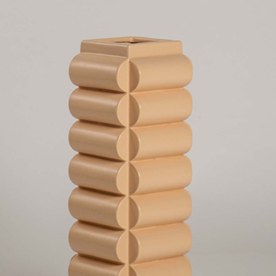 A detailed closeup of the beige geometric vase showing its rounded stacked pattern and smooth finish highlighting its modern artistic design.