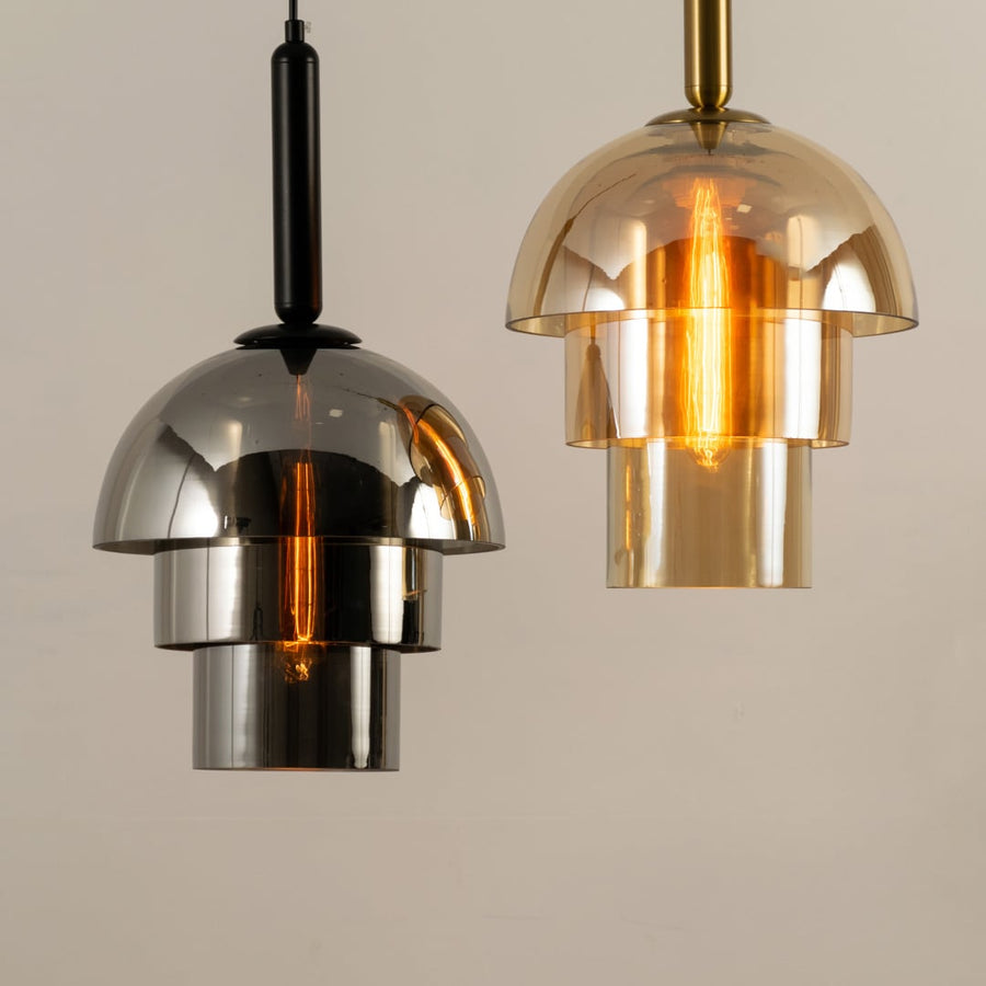 Pair of dome shaped pendant lights in silver and gold finishes glowing warmly and creating a sleek reflective focal point that enhances the contemporary interior.