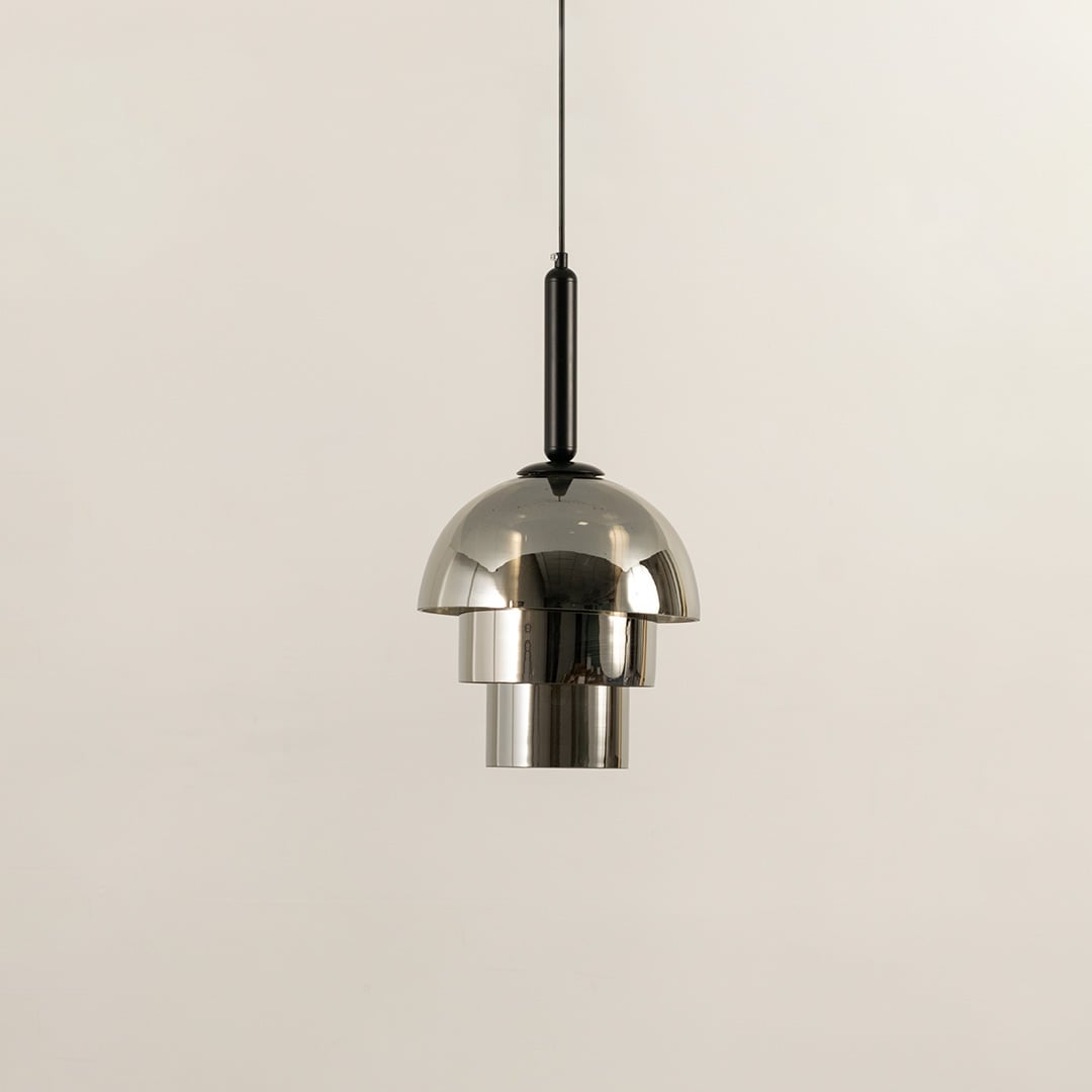 Silver metal pendant light shown unlit on white background highlighting dome shape polished finish and contemporary lighting style.