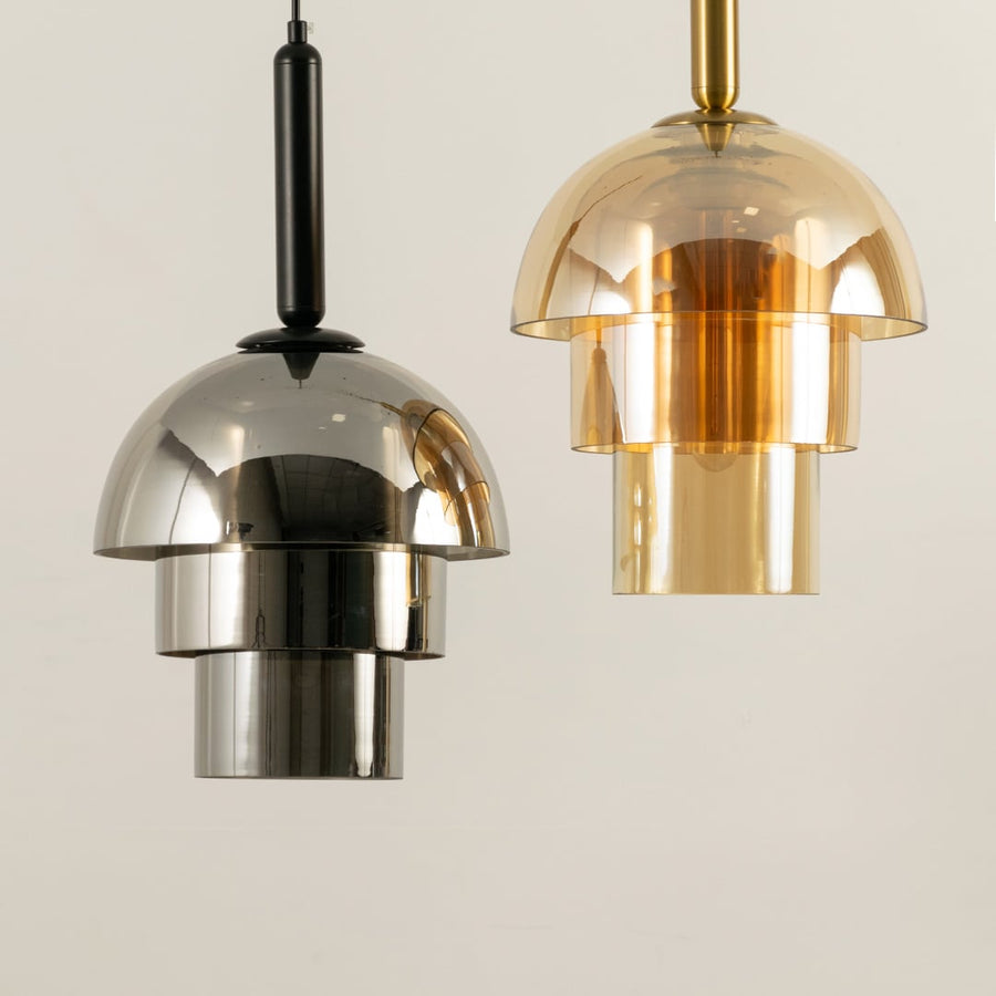 A grouped view of gold glass pendant lights displayed with lights off showcasing their layered shades and elegant modern aesthetic.
