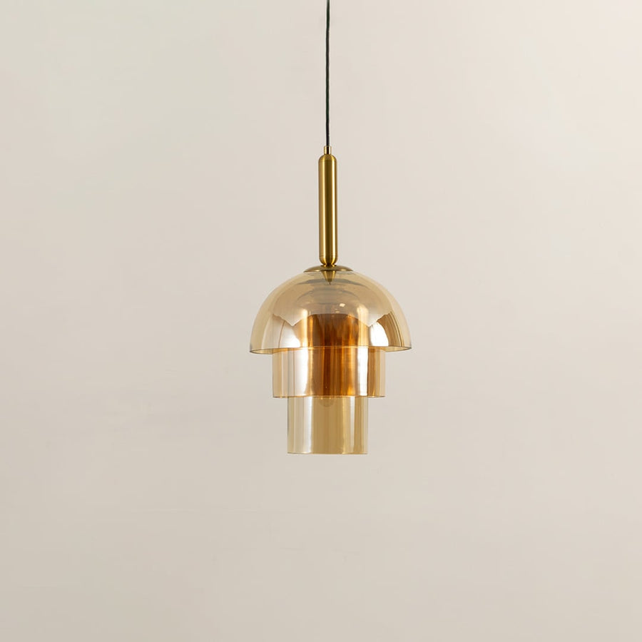 A gold glass pendant light shown with lights off on a clean white background highlighting its layered glass shade and elegant modern form.
