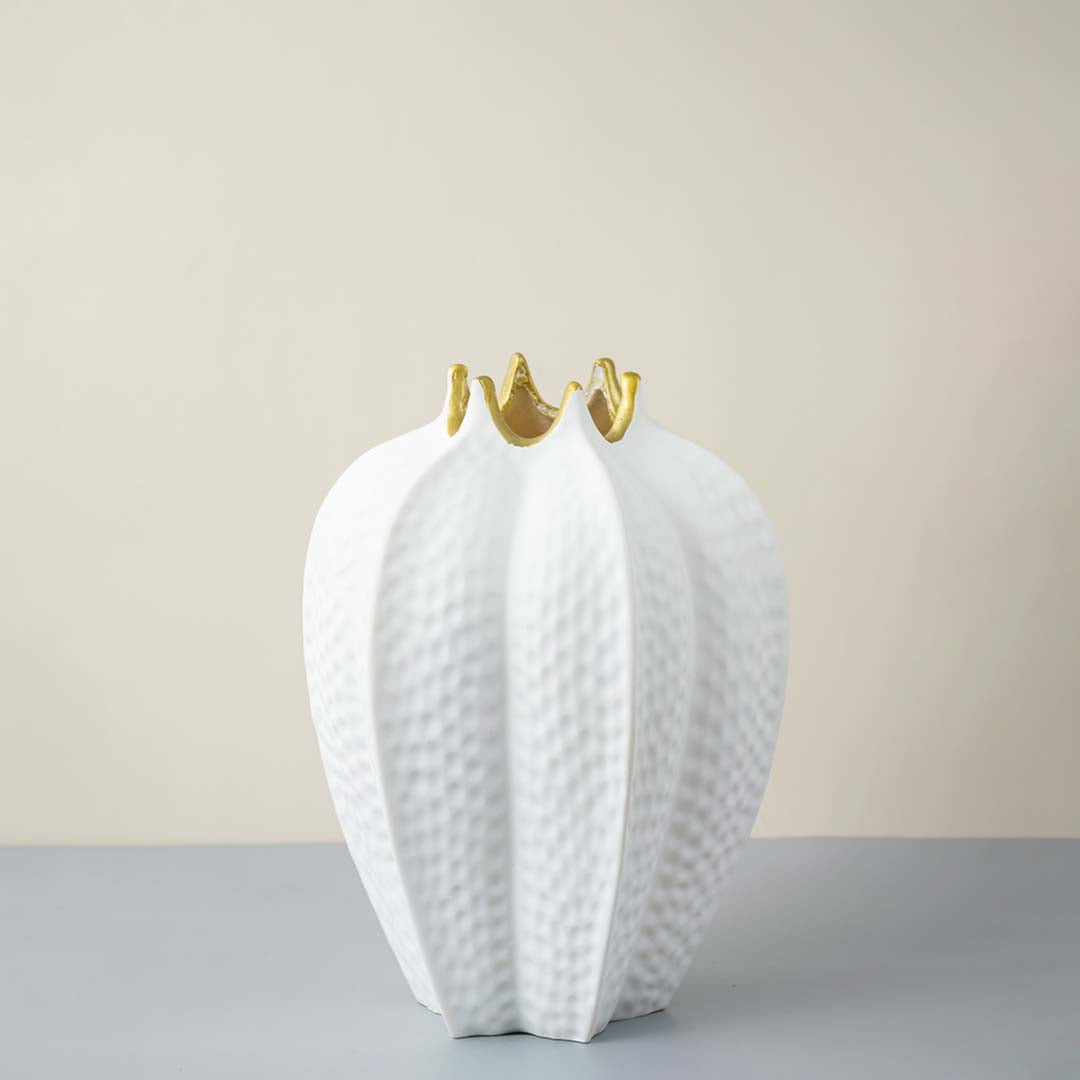 White ceramic decorative vase with textured leaf design and gold accents for elegant contemporary home decor styling.