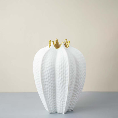 White ceramic decorative vase with textured leaf design and gold accents for elegant contemporary home decor styling.