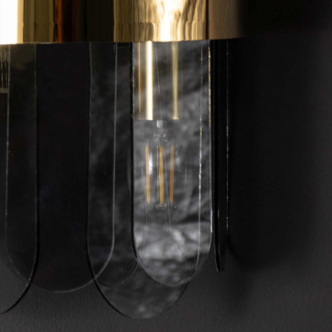 A closeup view of the metal and smoked glass wall light showing the layered curved glass panels and gold band detailing for premium home decor.