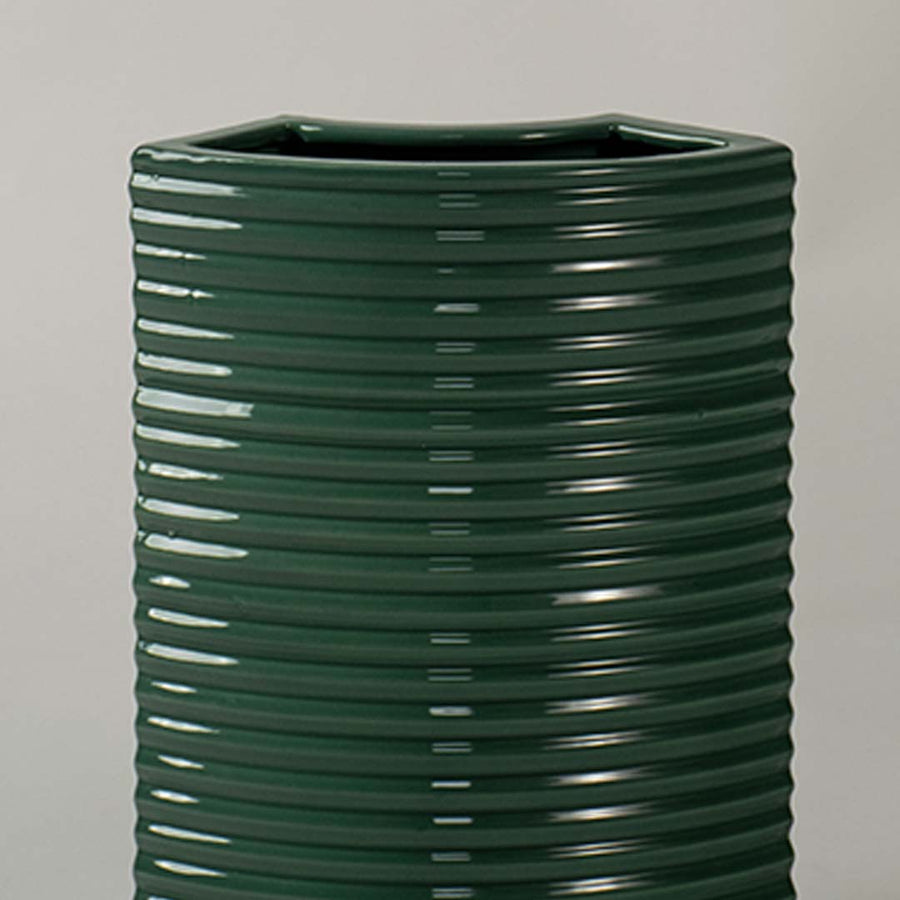 Closeup of dark green ribbed ceramic planter showing glossy textured detailing ideal for modern minimal home styling.