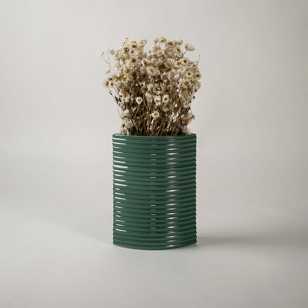 Tall dark green ceramic planter placed in a stylish interior setting perfect for living rooms hallways and modern decor accents.