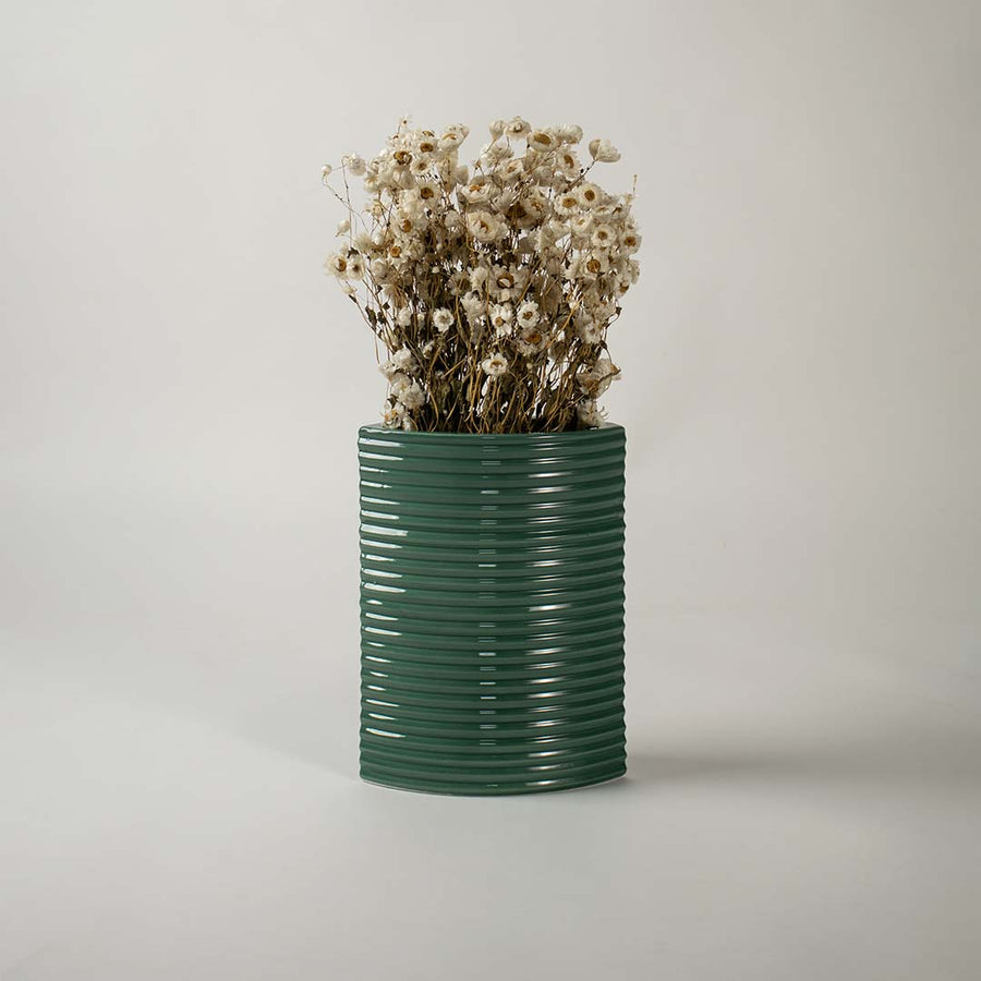 Tall dark green ceramic planter placed in a stylish interior setting perfect for living rooms hallways and modern decor accents.