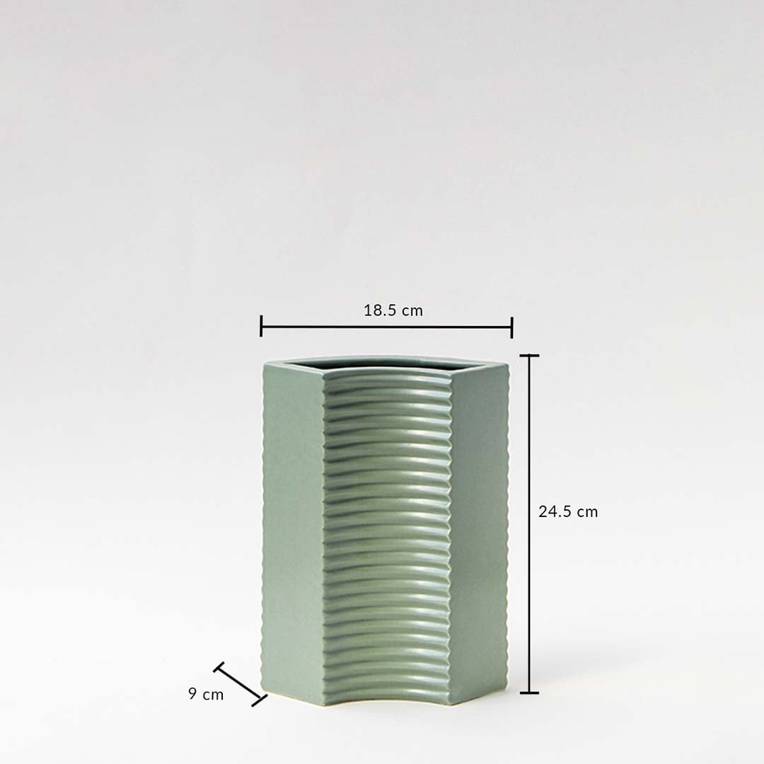 Green ceramic vase with ribbed surface and hexagonal shape shown with measurements — 24.5 cm tall  18.5 cm wide  9 cm deep.