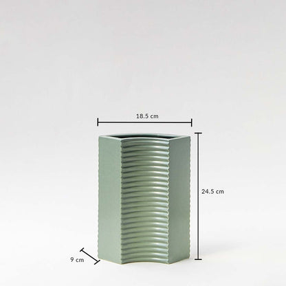 Green ceramic vase with ribbed surface and hexagonal shape shown with measurements — 24.5 cm tall  18.5 cm wide  9 cm deep.