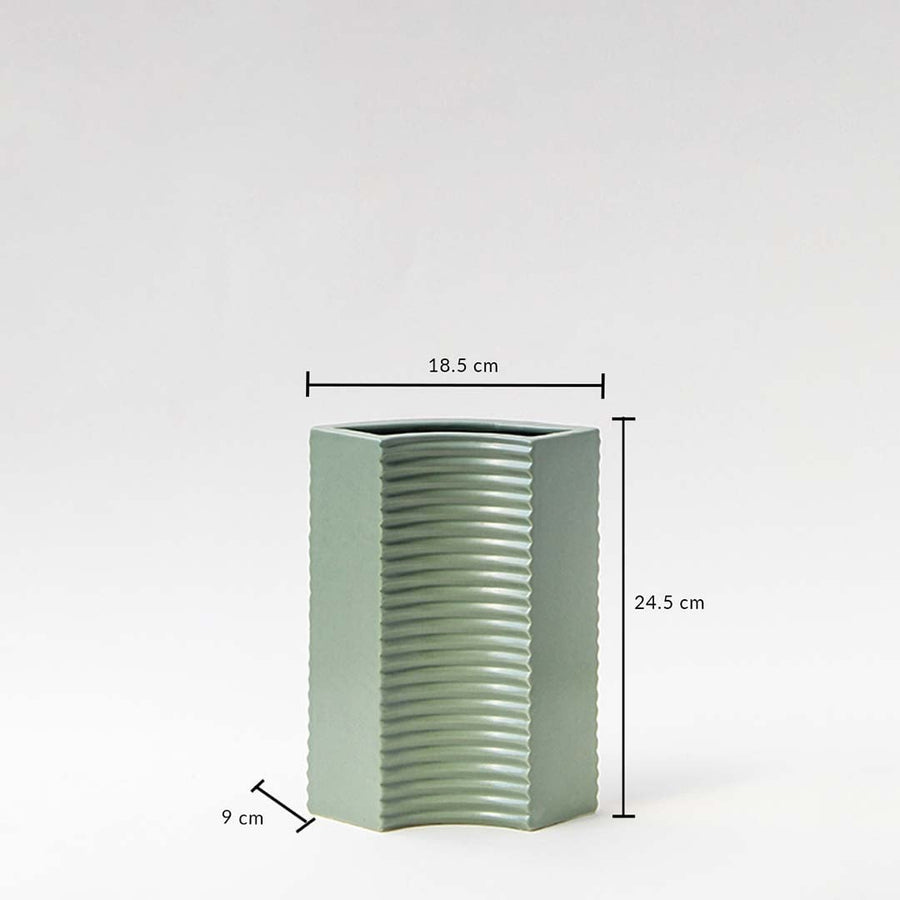 Green ceramic vase with ribbed surface and hexagonal shape shown with measurements — 24.5 cm tall  18.5 cm wide  9 cm deep.