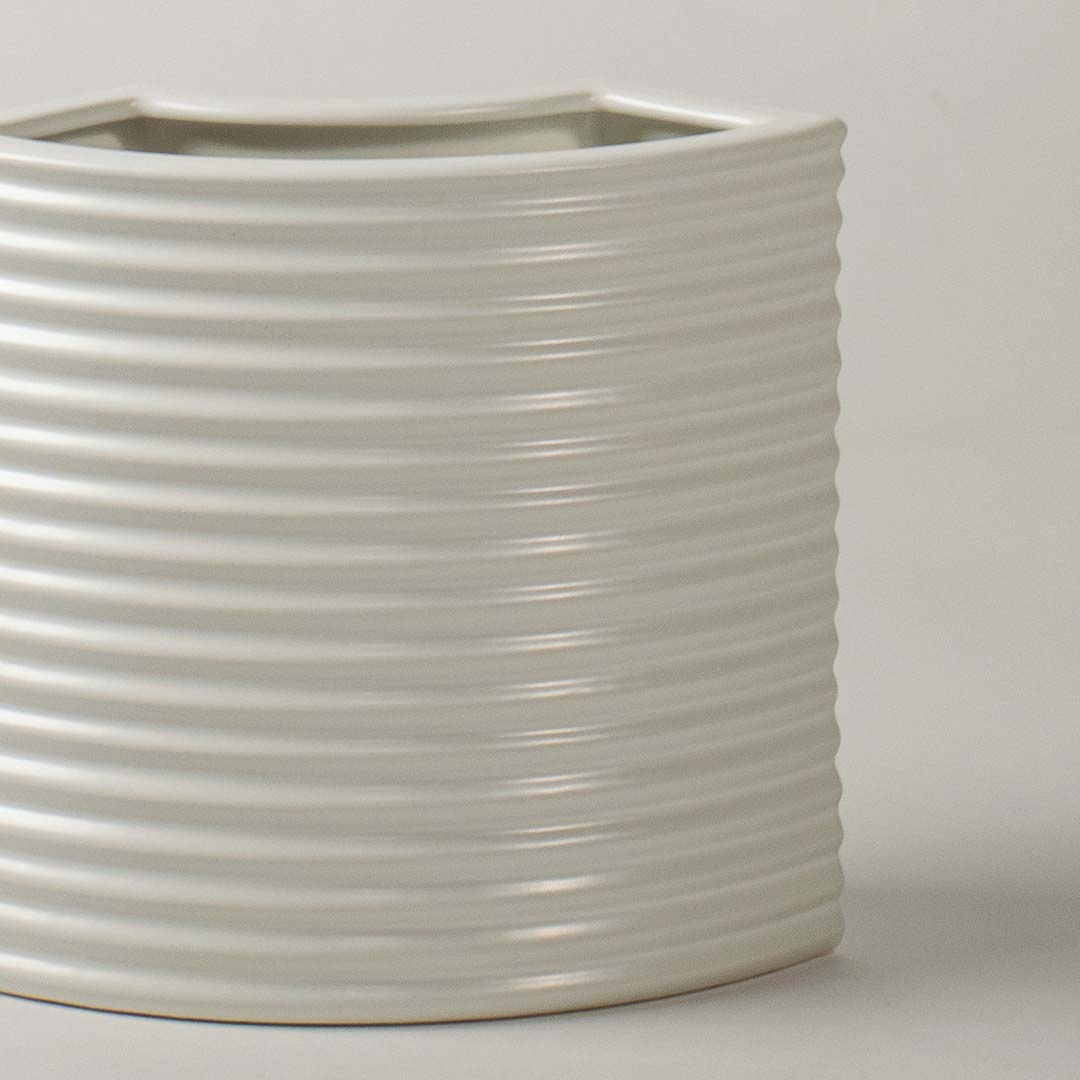 Closeup of white ribbed ceramic planter showing smooth textured detailing perfect for minimal modern home styling.