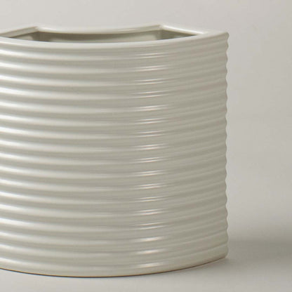 Closeup of white ribbed ceramic planter showing smooth textured detailing perfect for minimal modern home styling.