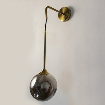 Elegant smoked glass and brass wall light on white background perfect for stylish contemporary living spaces.