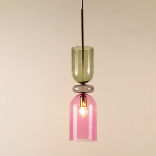Green and pink glass pendant light with metal frame illuminated to highlight modern decorative ceiling lighting.