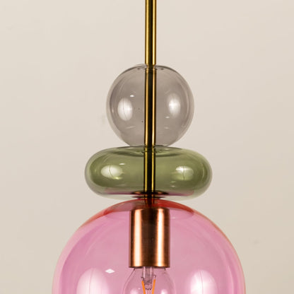 Close view of pink glass pendant light showing smooth texture colorful glass accents and elegant craftsmanship.
