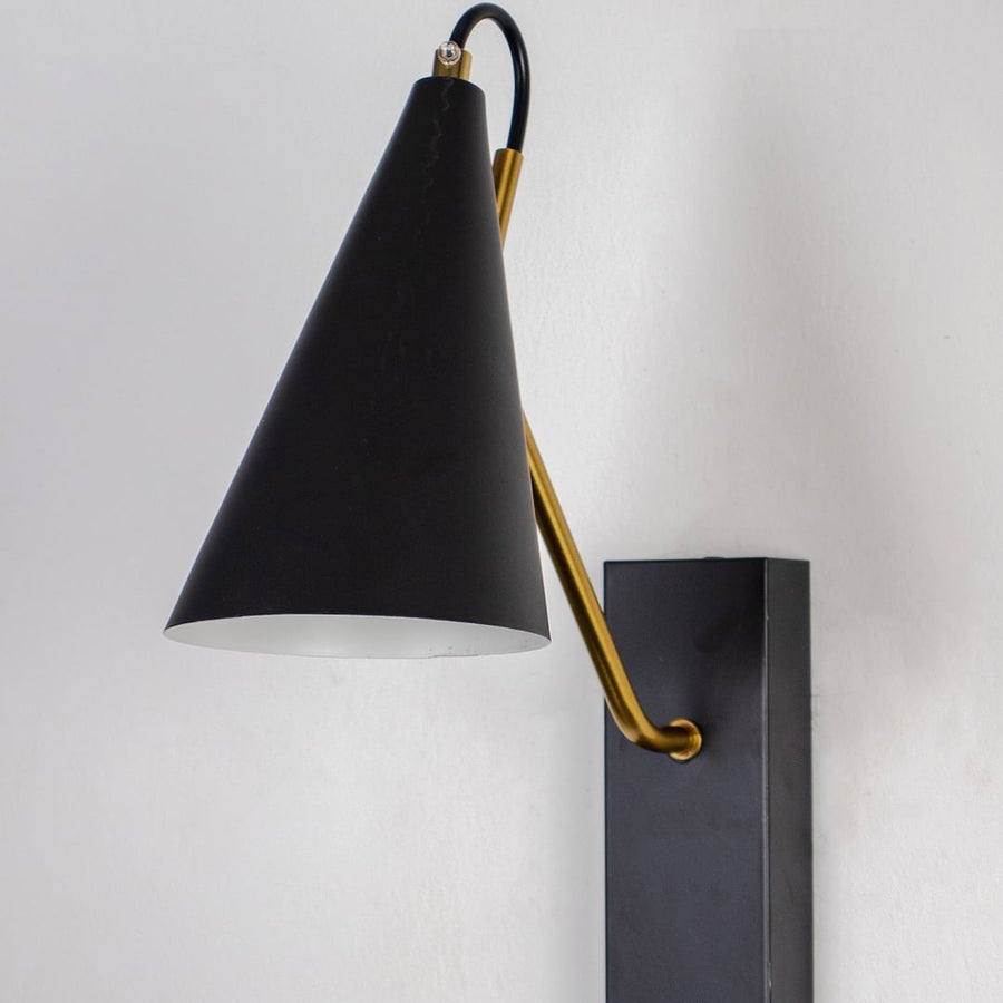 Elegant black wall light with matte conical shade and slim golden arm in closeup view showing modern minimal design.