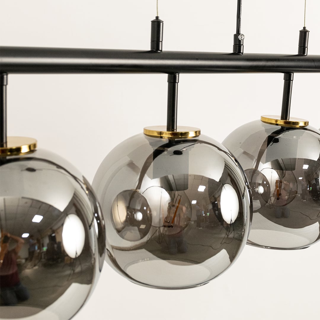Contemporary black chandelier with chrome glass globes styled in luxury interiors creating warm sophisticated illumination.