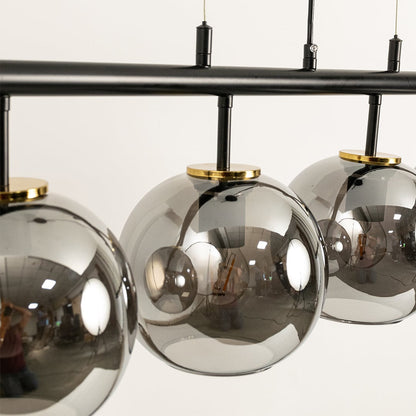 Contemporary black chandelier with chrome glass globes styled in luxury interiors creating warm sophisticated illumination.