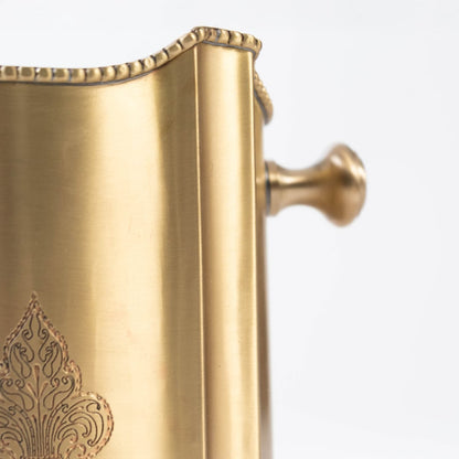 Detailed side view of scalloped gold brass container showing turned handle and rim beading against white backdrop.