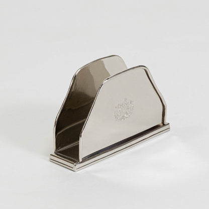Modern metal napkin holder in silver finish for dining table or kitchen decor accessory placement white background.