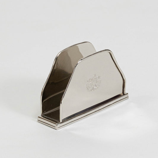 Modern metal napkin holder in silver finish for dining table or kitchen decor accessory placement white background.