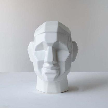 White ceramic decorative face sculpture with faceted geometric detailing for contemporary home decor displays.