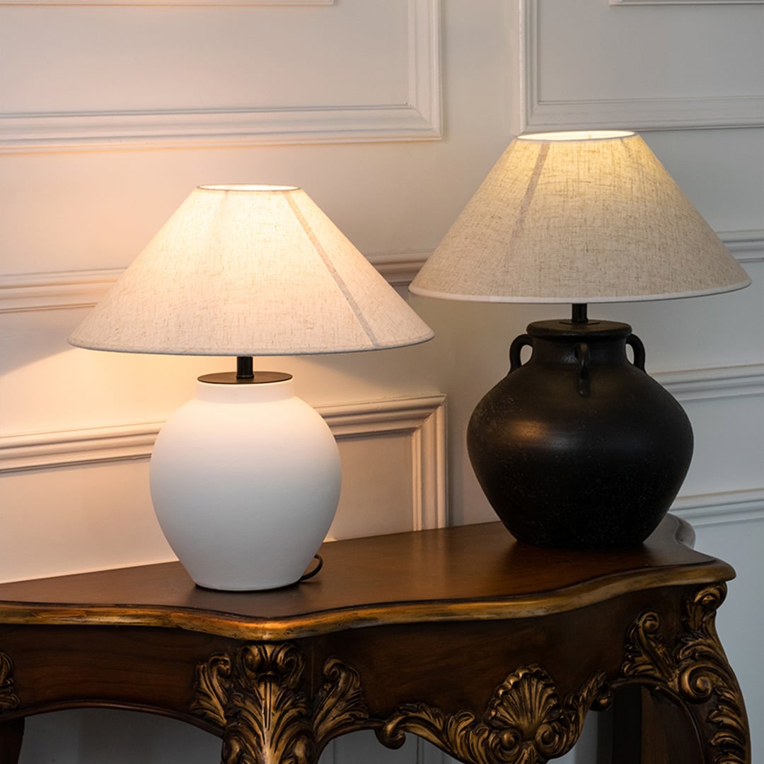 White ceramic table lamp with fabric shade paired with black ceramic lamp creating elegant traditional ambient lighting indoors.