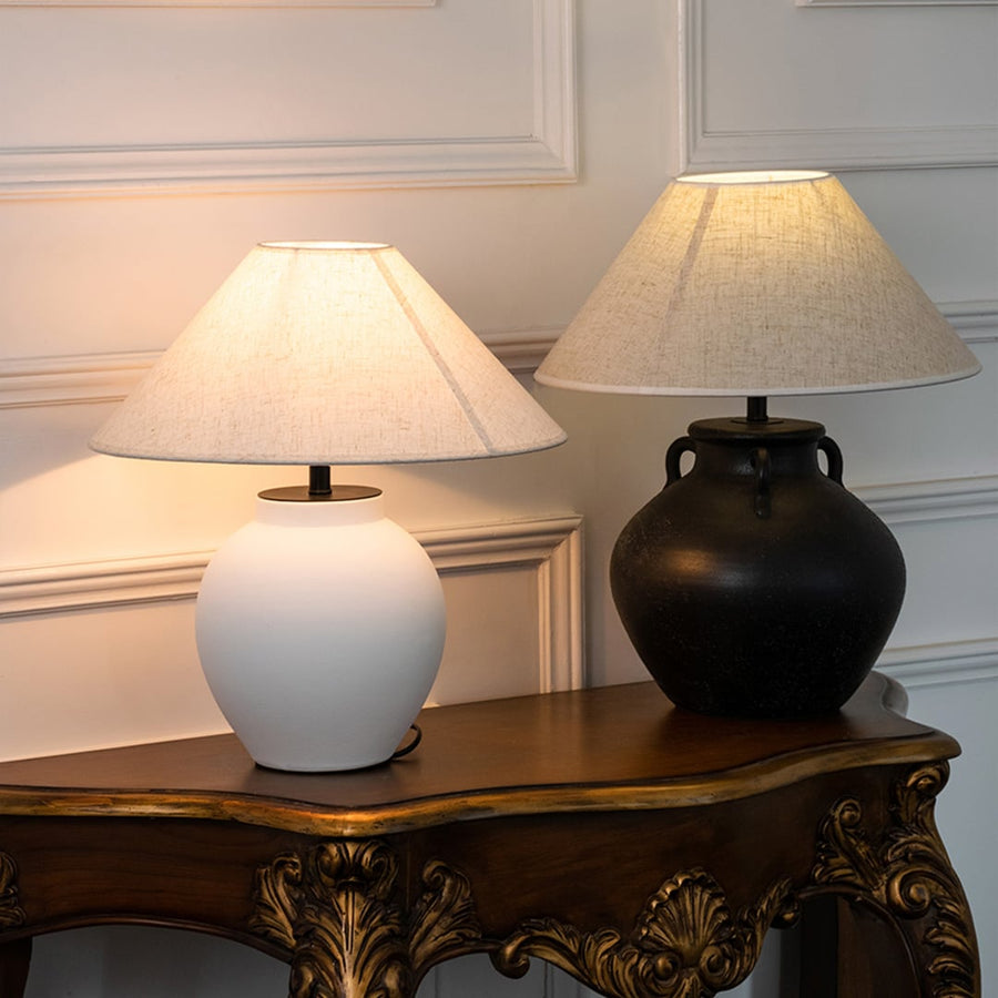 White ceramic table lamp with fabric shade paired with black ceramic lamp creating elegant traditional ambient lighting indoors.