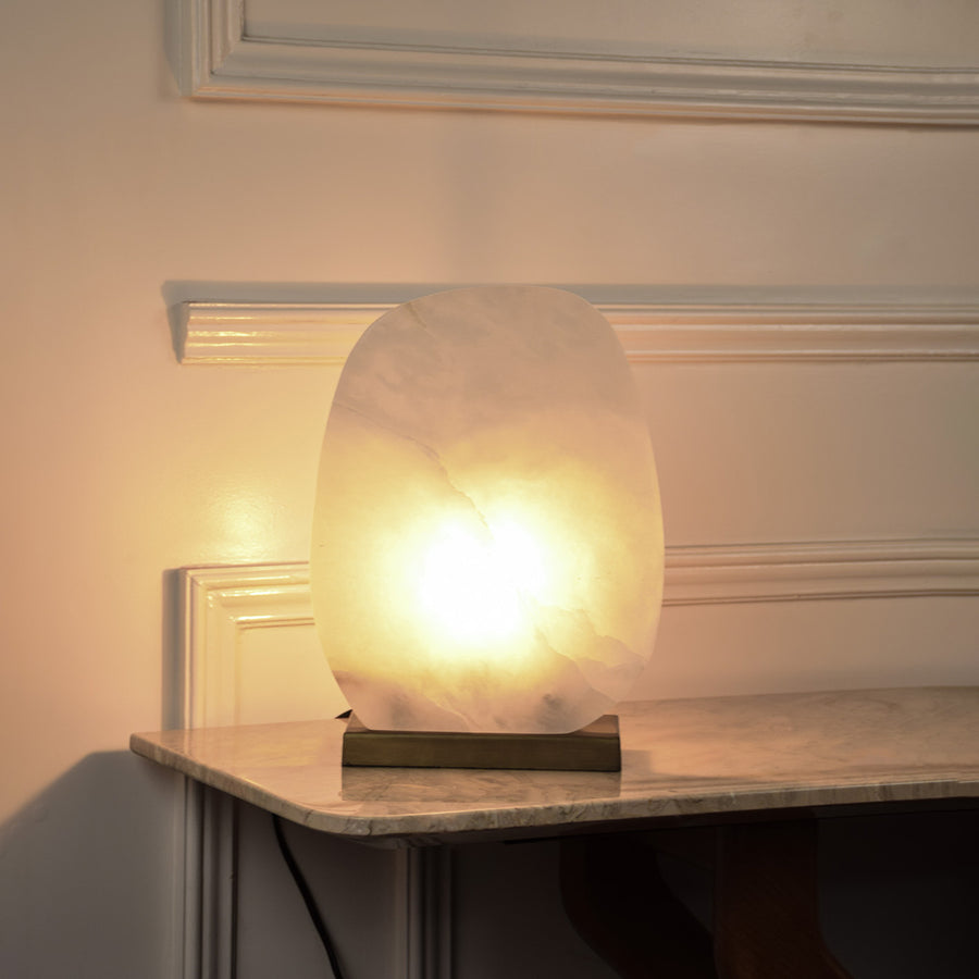 Marble effect globe table lamp with glowing stone shade creating soft ambient lighting for luxury interior decor.