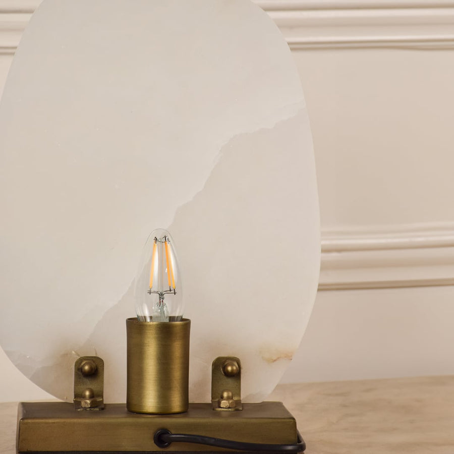 Closeup of marble table lamp showing natural veining and brass base craftsmanship reflecting premium quality and elegant design.