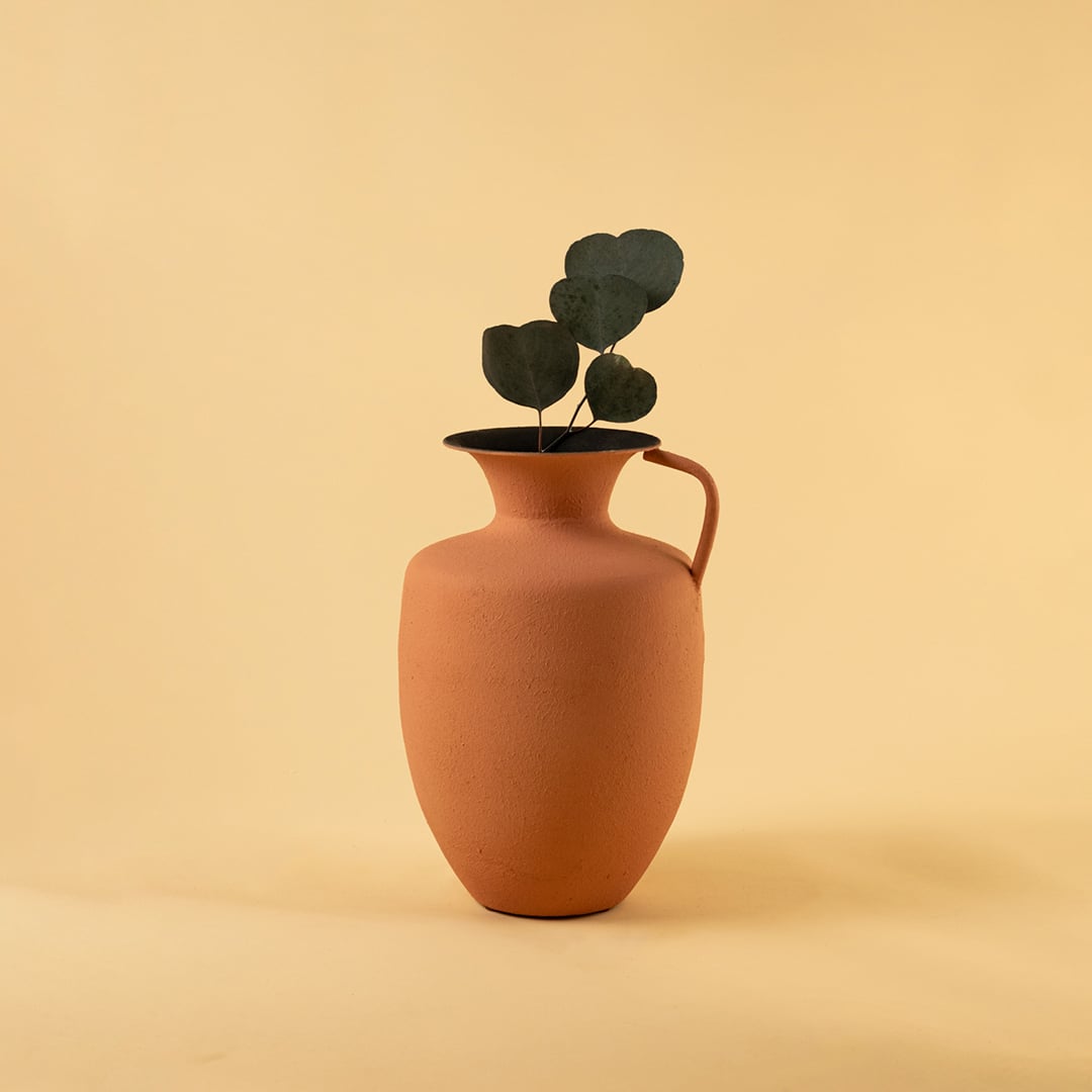 Terracotta metal jug vase decor styled in a warm modern room adding an earthy elegant accent to living room tables and corners.
