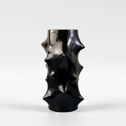 Elegant black ceramic vase with glossy finish and unique textured sculptural shape displayed on white background for home decor.