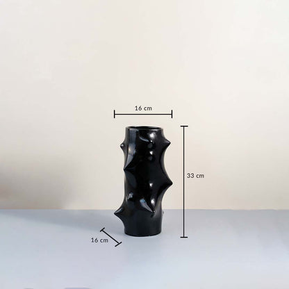 Black sculptural ceramic vase with glossy finish showing 33 cm height and 16 cm width with dimension guide on plain background.