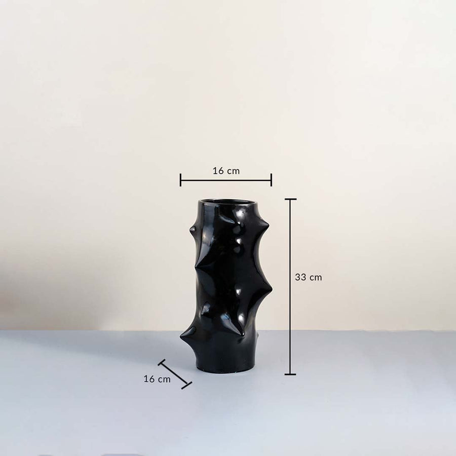 Black sculptural ceramic vase with glossy finish showing 33 cm height and 16 cm width with dimension guide on plain background.