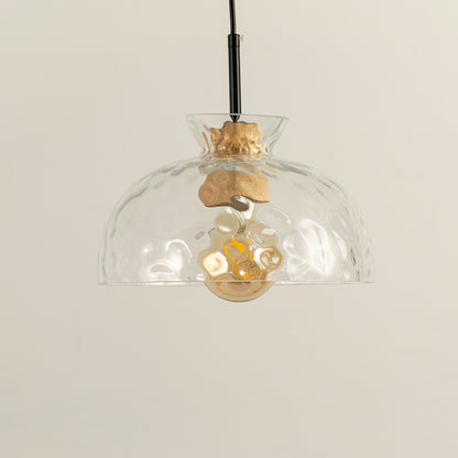 Clear wavy glass and brass metal pendant light designed for stylish dining room decor spaces.