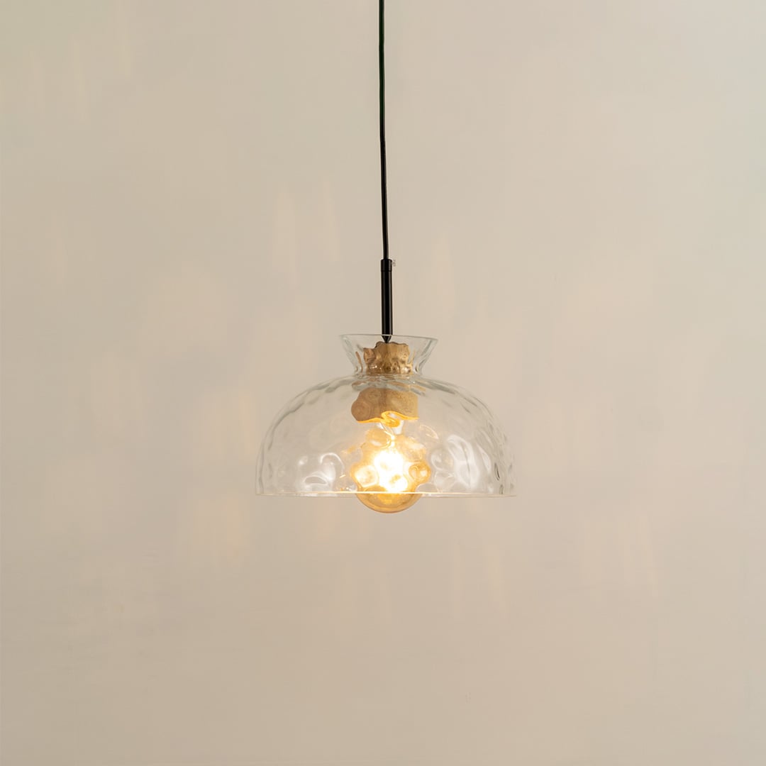 Clear sculpted glass and brass metal pendant light with warm glow for elegant modern interiors.
