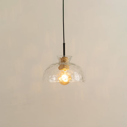 Clear sculpted glass and brass metal pendant light with warm glow for elegant modern interiors.