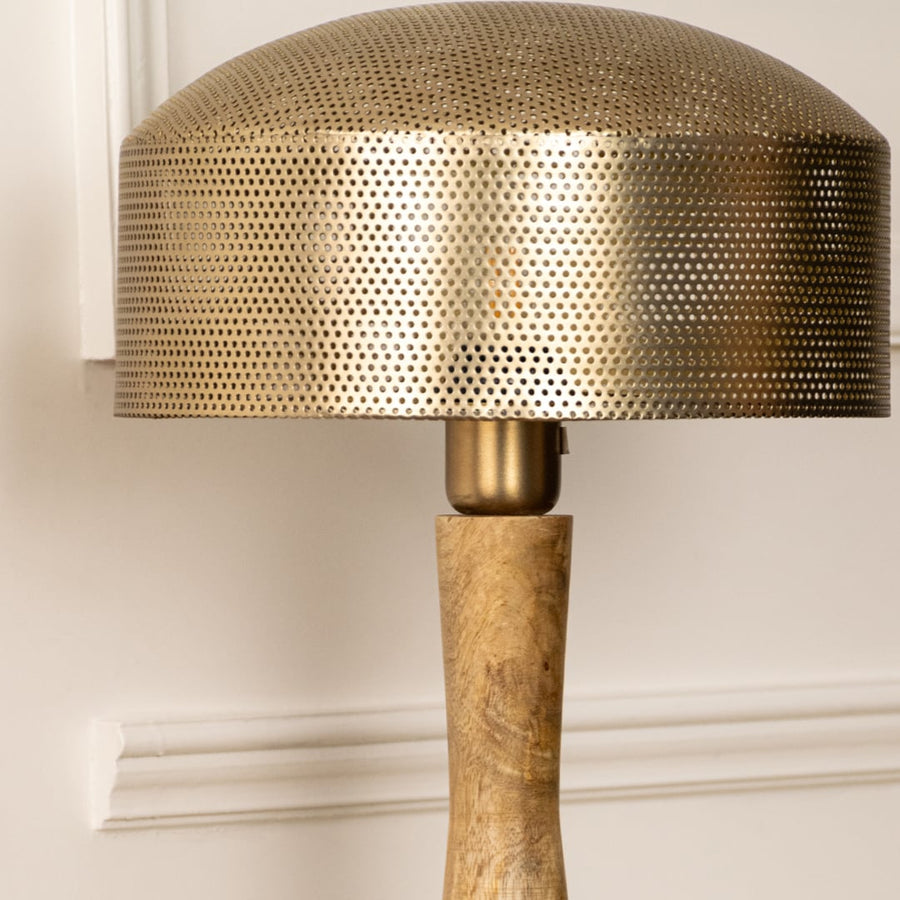 Closeup showing a metal shade and textured wooden base of table lamp reflecting expert craftsmanship and refined material contrast.