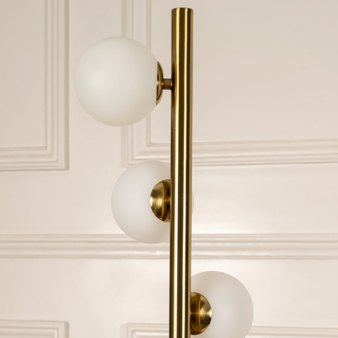 Detailed closeup of globe floor lamp globes and brass frame showing premium finish.