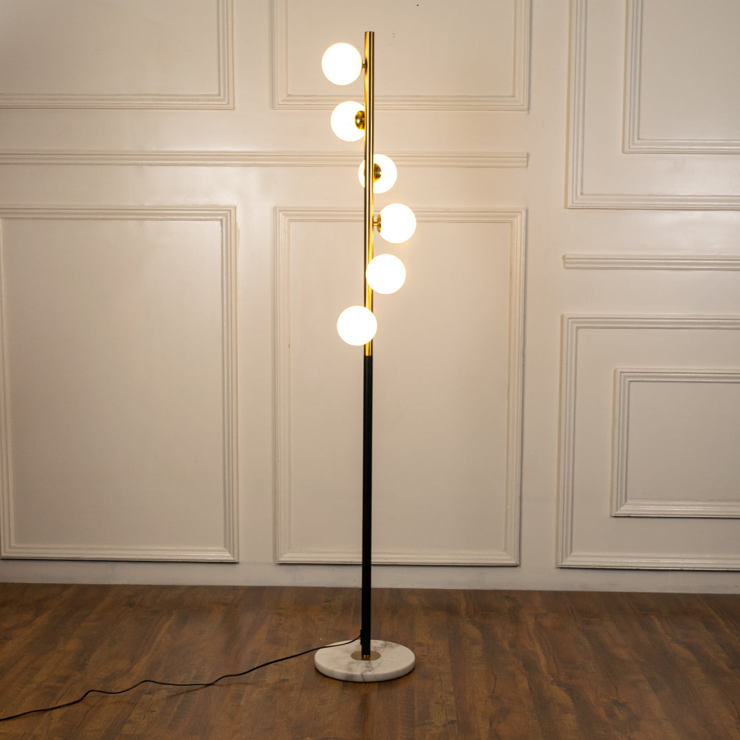Modern floor lamp with globe LED lights and brass finish providing warm ambient illumination for sophisticated interiors.