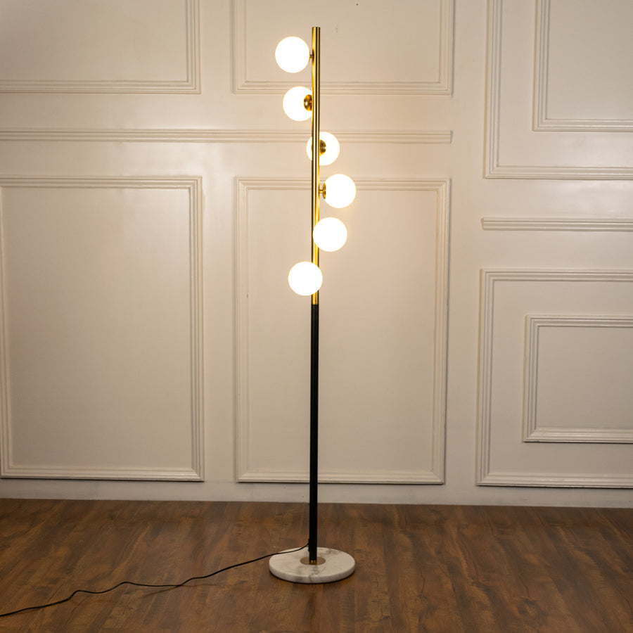 Modern floor lamp with globe LED lights and brass finish providing warm ambient illumination for sophisticated interiors.