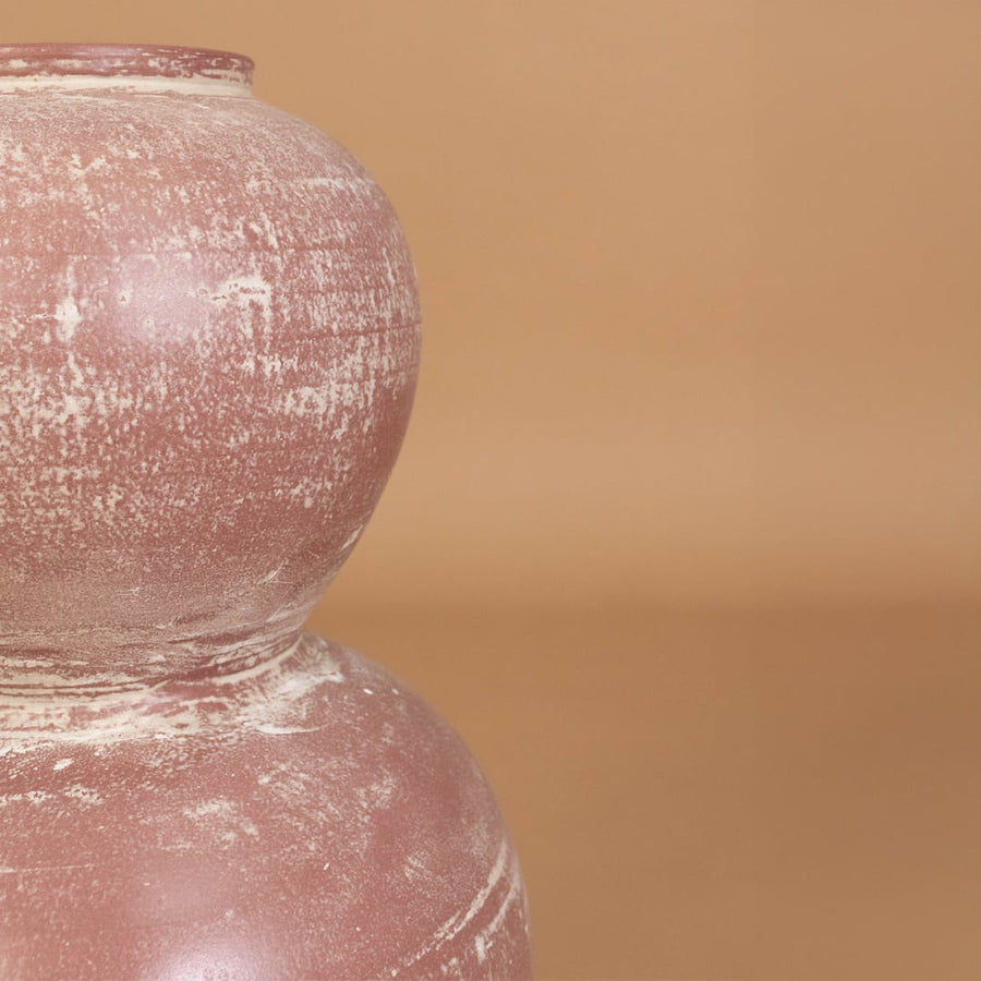 Closeup of rustic pink terracotta decorative vase showing detailed distressed texture and handcrafted style for modern artistic home decor.