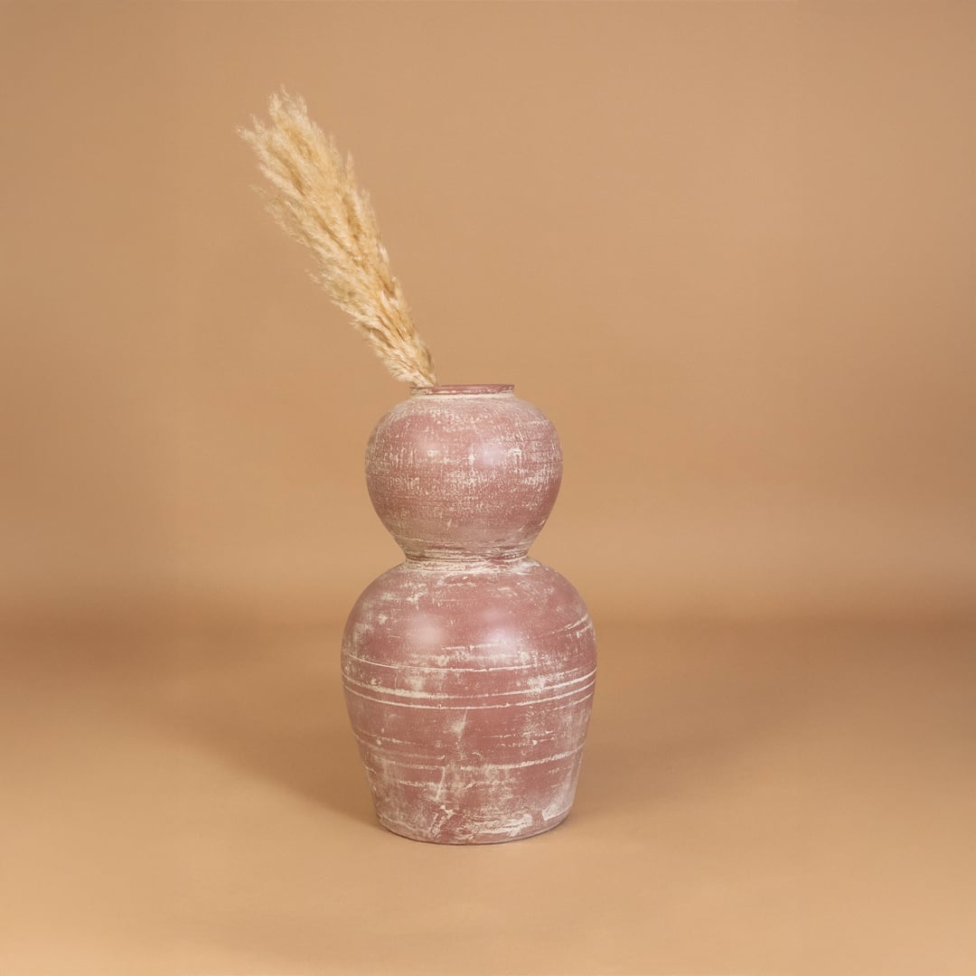 Rustic pink terracotta decorative vase placed in a styled interior adding earthy artistic decor to shelves consoles and contemporary living spaces.