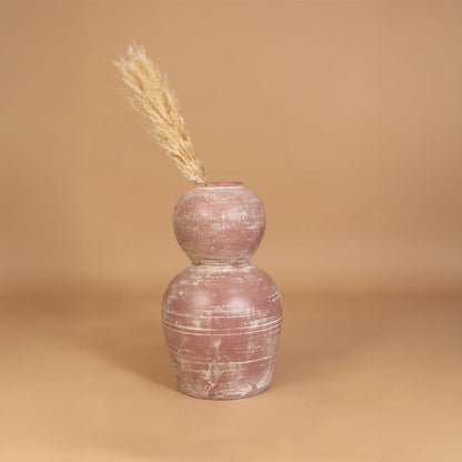 Rustic pink terracotta decorative vase placed in a styled interior adding earthy artistic decor to shelves consoles and contemporary living spaces.