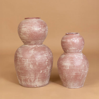 Rustic pink textured decorative vase displayed with coordinating decor pieces creating a stylish grouped arrangement for contemporary interiors.