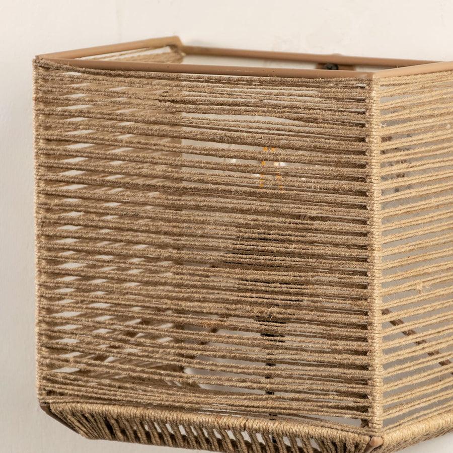 Detailed closeup of jute wall lamp showcasing its fine woven texture and expert craftsmanship that adds depth and organic appeal.