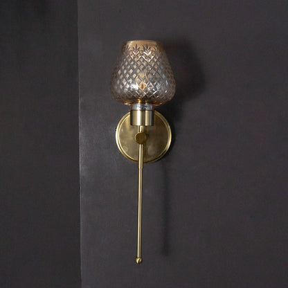 Sleek gold industrial wall sconce fixture turned off isolated on a pitch black background for dramatic contrast.