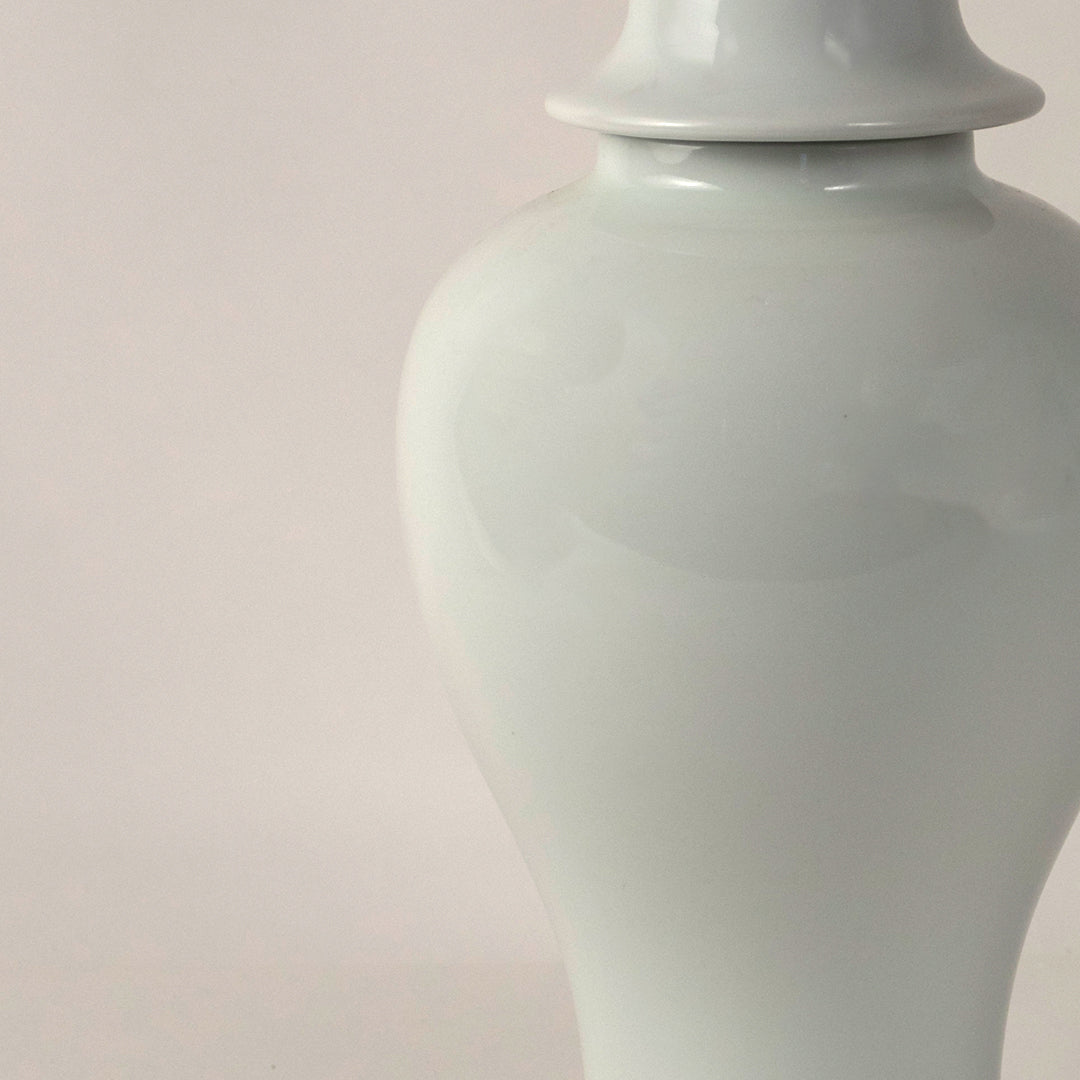 White ceramic pedestal vase with smooth finish placed on white surface against neutral background highlighting elegant minimal home decor aesthetic.