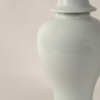White ceramic pedestal vase with smooth finish placed on white surface against neutral background highlighting elegant minimal home decor aesthetic.